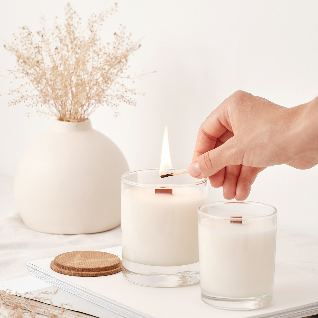 Person lighting a wood wick candle | The Eclectic Chic Boutique