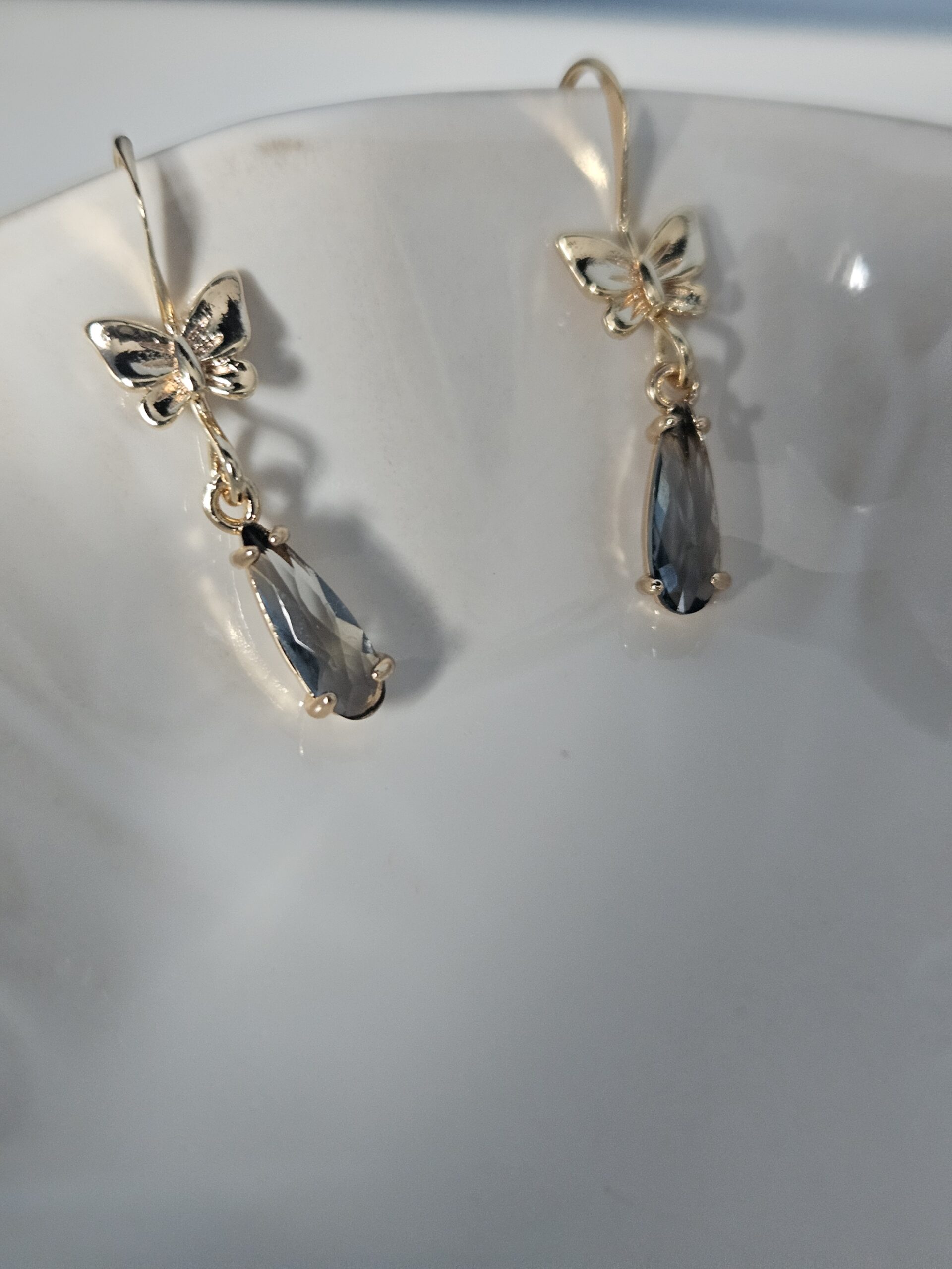 Gold bow drop earrings with smoky grey pendant