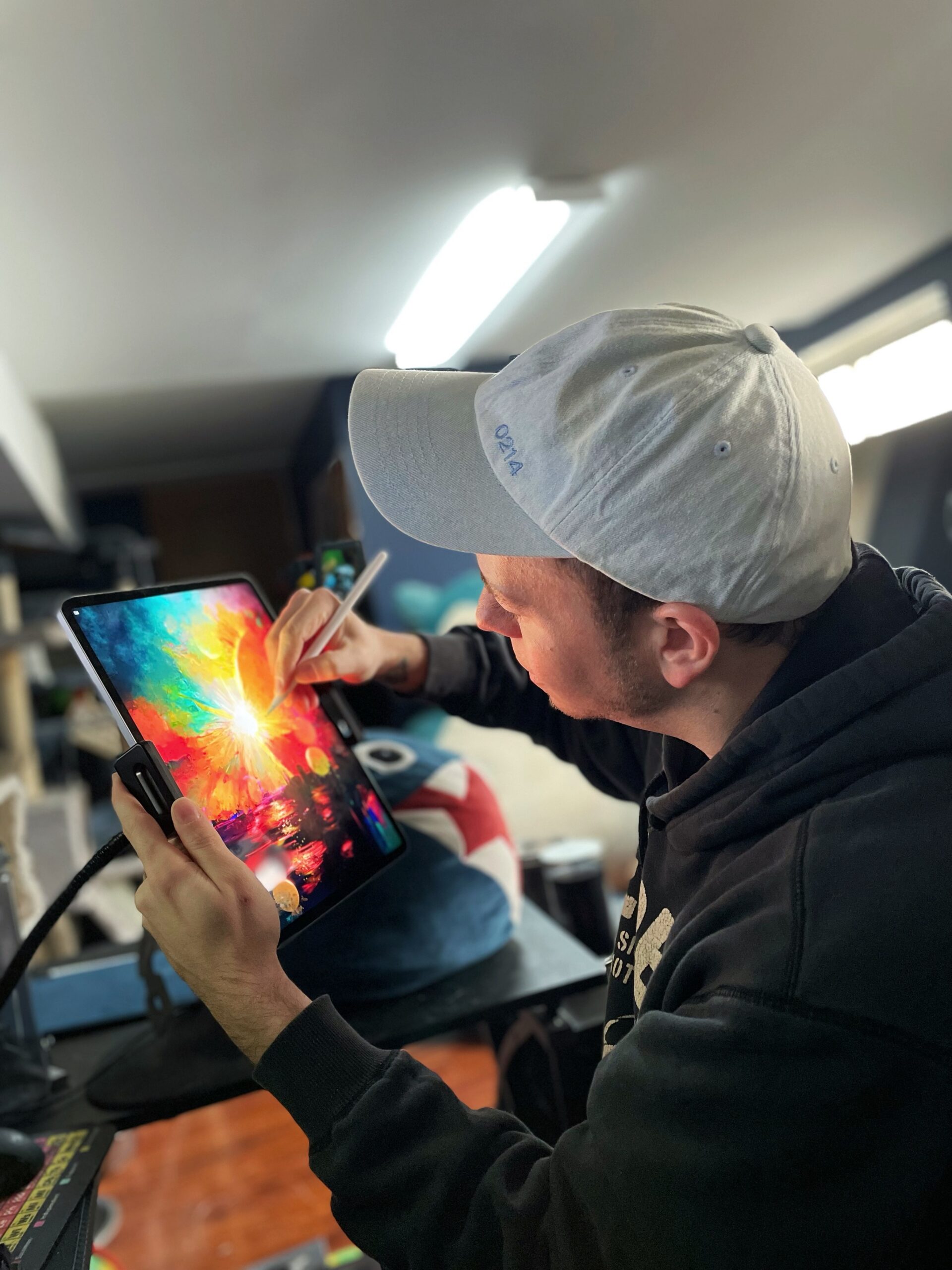 image of artist painting on ipad with colors exploding off device